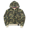 A Stussy camouflage zip-up hoodie with a green, brown, and tan camo pattern, featuring a black Stussy logo on the chest, a pink inner hood lining, and beige ribbed cuffs and hem.